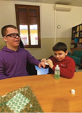 Two children learning how to apply a bandage